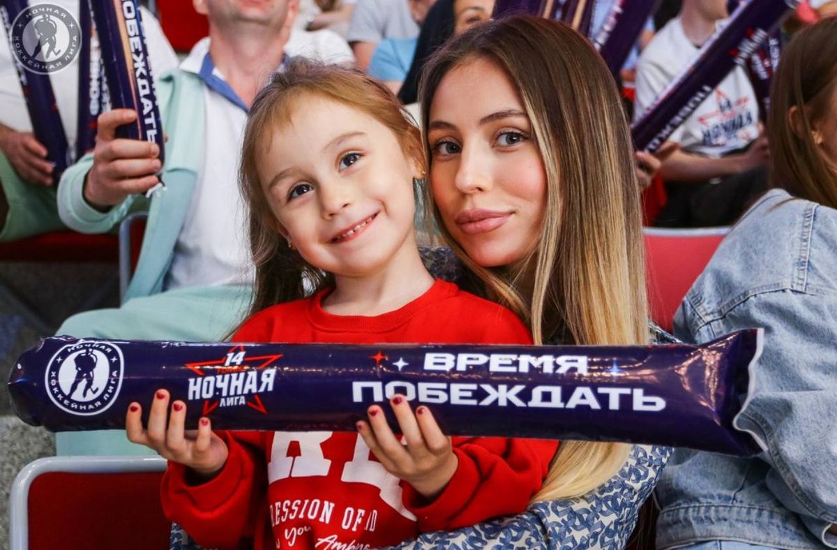 Мама с дочкой и фирменным клаппером на трибуне